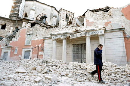 Un policier marchant sur les décombres des immeubles détruits par le séisme, dans le centre de L'Aquila, le 6 avril 2009.(Photo : Reuters)