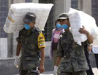 Les soldats mexicains transportent des cartons de masques de protection qui vont être distribués à la population, à Mexico, le 25 avril 2009.(Photo : Reuters)