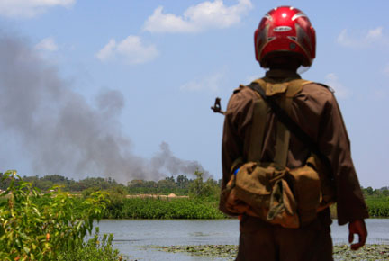 Un soldat sri lankais observe un nuage de fumée du côté de la ville de Putumatalan dans le nord du Sri Lanka, le 24 avril 2009.( Photo : Reuters )