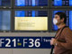 Un voyageur à l'aéroport français Charles-de-Gaulle passe devant un écran d'information sur la grippe porcine.(Photo : Gonzalo Fuentes/Reuters)