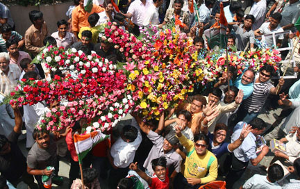 Des supporters&nbsp;du Parti du Congrès portent un bouquet de fleurs géant destiné aux vainqueurs des élections, dans la ville de Chandigarh.(Photo : Reuters)
