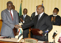 Le ministre tchadien des Affaires étrangères Moussa Faki Mahamat (g) et le ministre soudanais de Coopération internationale al-Tijani Saleh Fidail lors de la signature d'un accord à Doha, le 3 mai 2009.(Photo : AFP)