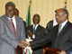 Le ministre tchadien des Affaires étrangères Moussa Faki Mahamat (g) et le ministre soudanais de Coopération internationale al-Tijani Saleh Fedail lors de la signature d'un accord à Doha, le 3 mai 2009.(Photo : AFP)