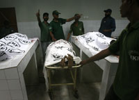 Des infirmiers de l'hôpital de Karachi autour des talibans tués par l'armée pakistanaise, le 27 juin 2009.(Photo : Reuters)