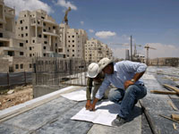 Des ouvriers examinent des plans de construction d'une colonie près de Jérusalem, le 5 juillet 2009.(Photo : Reuters)