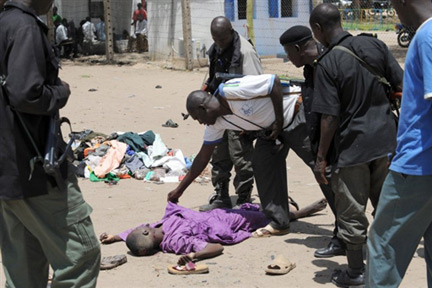 Des policiers nigérians autour d'un cadavre, à Maiduguri, le 29 juillet 2009.(Photo : AFP)