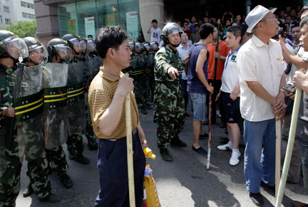 Un rassemblement de Chinois de l'ethnie Han armés de batons de bois et de fer devant des soldats chinois, le 7 juillet 2009 à Urumqi.(Photo : Reuters)