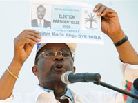 Le candidat indépendant Casimir Oye Mba brandissant un bulletin de vote fictif lors d'un meeting près de Libreville, au Gabon, le 21 août.(Photo :  Yanick Maniengui/AFP)