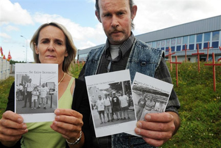 Chantal Jouan (g), déléguée syndicale CGT et Joël Moro (d), employé, montrent trois des cartes postales éditées par les salariés menacés de licenciement de l'entreprise Chaffoteaux-et-Maury à Ploufragan, près de Saint-Brieuc, le 7 août 2009.(Photo : AFP)