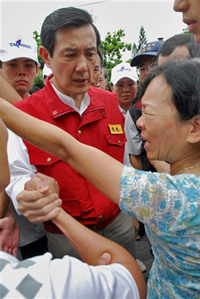 Le président taïwanais Ma Ying-jeou réconforte une survivante, le 10 août 2009.(Photo : AFP)