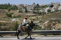 Un Palestinien passe devant une colonie juive en Cisjordanie à Elazar à 20 km au sud de Jérusalem, le 19 juin 2009.(Photo: AFP)