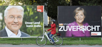 A Berlin, une cycliste passe devant les affiches de campagne éléctorale d'Angela Merkel et de Frank-Walter Steinmeier. (Photo : AFP)