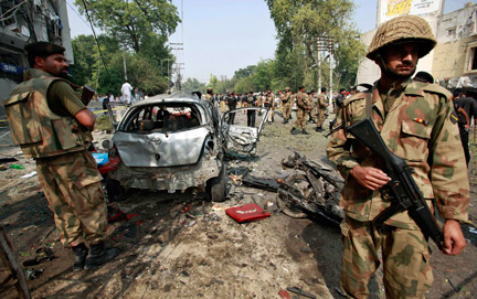 Des soldats pakistanais gardant le site où a explosé une voiture piégée, dans la ville de Peshawar, le 26 septembre 2009.(Photo : Reuters)