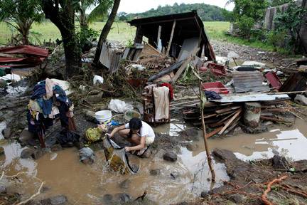 Une Philippine lavant ses vêtements devant sa maison complètement détruite par les flots, à l'est de Manille, le 28 septembre 2009.(Photo : Reuters)