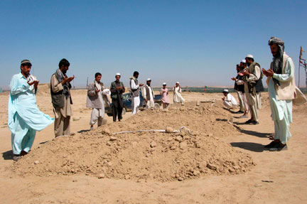 Des villageois prient sur les tombes des victimes civiles de la frappe meurtrière de l'OTAN, le 5 septembre 2009.(Photo: Reuters)