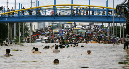 Des habitants de l'est de Manille se déplacent en nageant parmi les véhicules, le 27&nbsp;septembre 2009.(Photo : Reuters)