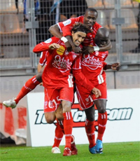 Youssouf Hadji félicité par ses coéquipiers après son pénalty victorieux à Grenoble.(Photo: AFP / Jean-Pierre Clatot)