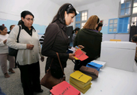 Dans un bureau de vote, des femmes s'apprêtent à faire leur choix avant de passer dans l’isoloir, pour l'élection présidentielle en Tunisie, le 25&nbsp;octobre 2009.(Photo : Reuters)