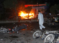 Samochód płonie w pobliżu ciężarówki, którą jechała Benazir BhuttoFot. Reuters