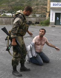 Русский военный задерживает человека, пытавшегося провезти оружие в машине через КПП на въезде в грузинский город Гори(Photo : REUTERS/Gleb Garanich)