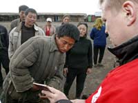 Сотрудник Миграционной службы России проверяет паспорт у китайского трудового мигранта(Photo: REUTERS)