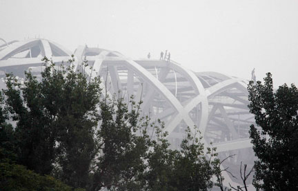 Le futur stade olympique de Pékin, surnommé «le nid d'abeilles», en construction, dans le brouillard du mois d'août.(Photo : Reuters)
