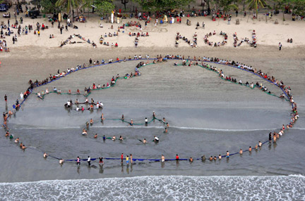 Une chaîne humaine&nbsp;formée de plusieurs centaines de militants écologistes réunis sur la plage de Kuta à Bali, ce dimanche 9 décembre 2007.(Photos : Reuters)