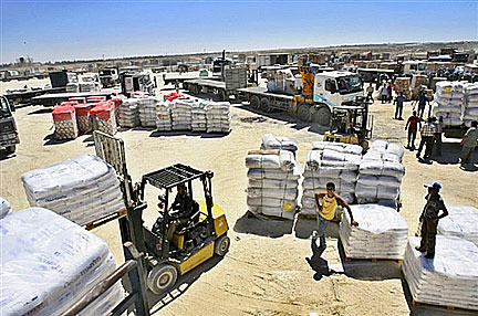 Des ouvriers palestiniens reçoivent des marchandises délivrées au point de passage de Sufa entre Israël et la Palestine.(Photo : AFP)