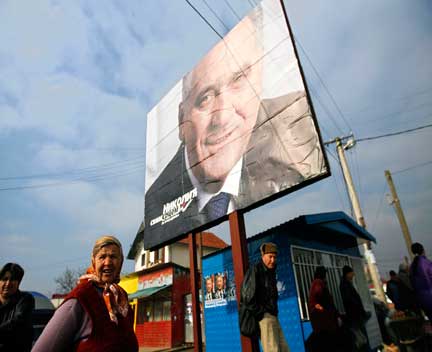 Des habitants du village isolé de Gracanica, au Kosovo, passent sous un panneau d'affichage à l'effigie du candidat de l’extrême droite nationaliste Tomislav Nikolic.(Photo : Reuters)