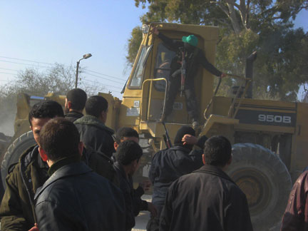 Un membre masqué des Brigades Ezzedine Kassam jugé sur le bulldozer qui ouvre une nouvelle brèche dans la frontière.(Photo : Catherine Monnet/RFI)