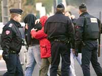 Les deux policiers escortent l'un des membres de l'ETA pour perquisitionner la villa de Saint-Jean-de-Luz, ce 16 février 2008, où les 4 suspects ont été arrêtés la veille. (Photo : AFP)