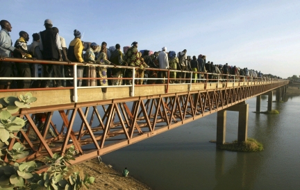 Des réfugiés traversent par milliers le pont Nguéli qui enjambe la rivière Logone et mène vers le Cameroun.(Photo : Reuters)