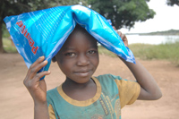 Une fille dans un village Angolais, avec un sac d'insecticide.(Crédit: <a href="www.zambezi-expedition.org" target="_blank">Helge Bendl</a>)