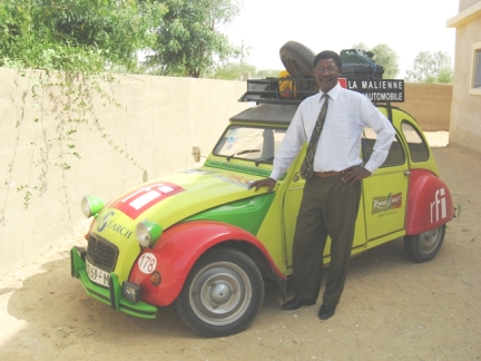 Souleymane Camara, le patron de CHEMAMA. La deuche le transporte quelques années en arrière, aussi c’est tout ému, qu’il pose devant notre véhicule.(Photo : Manu Pochez)