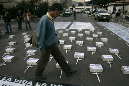 Un homme marche le long les croix et tombes symboliques des victimes des paramilitaires colombiens, lors d'une manifestation en face de l'ambassade du Costa Rica à Bogota, mardi 22 avril 2008. (Photo : Reuters)