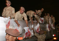 Des soldats péruviens déchargent des sacs de riz destinés aux familles les plus démunies.(Photo : Reuters)