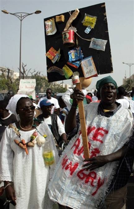 Des manifestants brandissent des miches de pain, des sacs de riz vides et d'autres aliments, lors d'une marche organisée par l'opposition le 26 avril à Dakar pour protester contre la vie chère.(Photo : AFP)