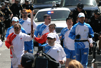 Les porteurs de la flamme olympique sont encerclés par un imposant service de l'ordre, ce qui n'a pas empêché les manifestants de perturber le parcours.(Photo : Reuters)