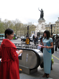 Des jeunes filles chinoises, en robes de soie traditionnelle, distribuant des tracts à la sortie du métro République, à Paris, le 19 avril 2008.(Photo : S. Lagarde/RFI)