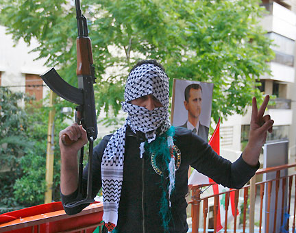 Un milicien du Hezbollah pose devant un portrait du président syrien, Bachar al-Assad, à Beyrouth le 9 mai 2008.(Photo : Reuters)