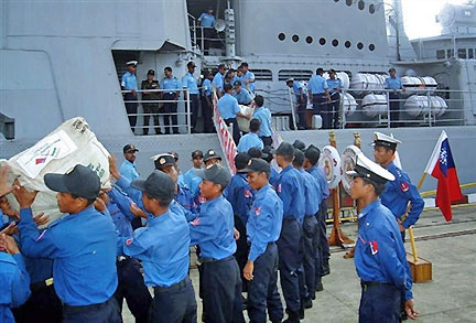 Des marins birmans (en bleu foncé) réceptionnent l'aide apportée par l'Inde aux côtés de marins indiens à Rangoon, le 7 mai 2008.(Photo : AFP)