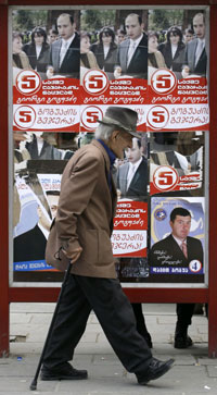 Un passant devant un abribus tapissé d'affiches des candidats aux législatives, le 20 mai 2008 à Tbilissi, capitale géorgienne. (Photo : Reuters)