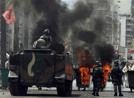 Des soldats libanais regardent des manifestants brûler des pneus, dans une des rues de Beyrouth, le 7 mai 2008, lors de la grève générale qui a tourné aux combats de rue.(Photo : AFP)