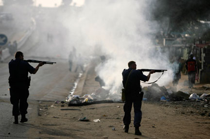 Des policiers visent une cible, durant les affrontements anti-étrangers dans la banlieue de Johannesburg, le 18 mai 2008. Des centaines d'immigrants ont trouvé refuge dans les commissariats de police ou les églises.(Photo: Reuters)