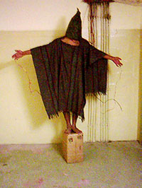 Un prisonnier irakien de la prison d'Abou Ghraïb. L'une des images qui suscita un tollé.(Source: Wikipédia)