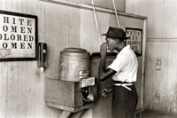 A Oklahoma City en 1939, un jeune homme boit à la fontaine de la gare routière, réservée aux gens de couleur. Les lois Jim Crow invitaient à la ségrégation raciale.(Source: Wilkipédia)