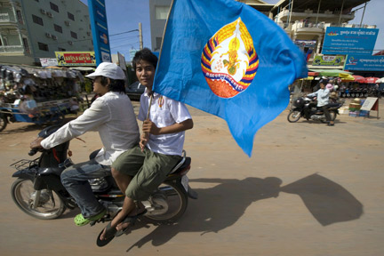 Un militant du PPC, le Parti du peuple cambodgien de Hun Sen, arbore un drapeau aux couleurs du parti dans les rues de Siem Reap.(Photo : Reuters)
