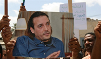 Le portrait d'Hannibal Kadhafi, brandi par ses soutiens ce mercredi, à l'extérieur de l'ambassade suisse de Tripoli.(Photo : AFP)
