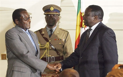 Le président zimbabwéen Robert Mugabe (g) serre la main du leader de l'opposition Morgan Tsvangirai (d), le 21 juillet 2008, après la signature d'un protocole d'accord pour faire sortir le pays de sa crise politique.(Photo : AFP)