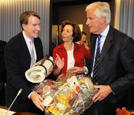 Le commissaire européen au Commerce Peter Mandelson (à gauche), a été pris au mot par le ministre français de l'Agriculture, Michel Barnier (à droite), qui lui a offert, avec Anne-Marie Idrac, la&nbsp;secrétaire d'Etat au Commerce extérieur (au centre),&nbsp;un panier garni de produits européens.(Photo : AFP)